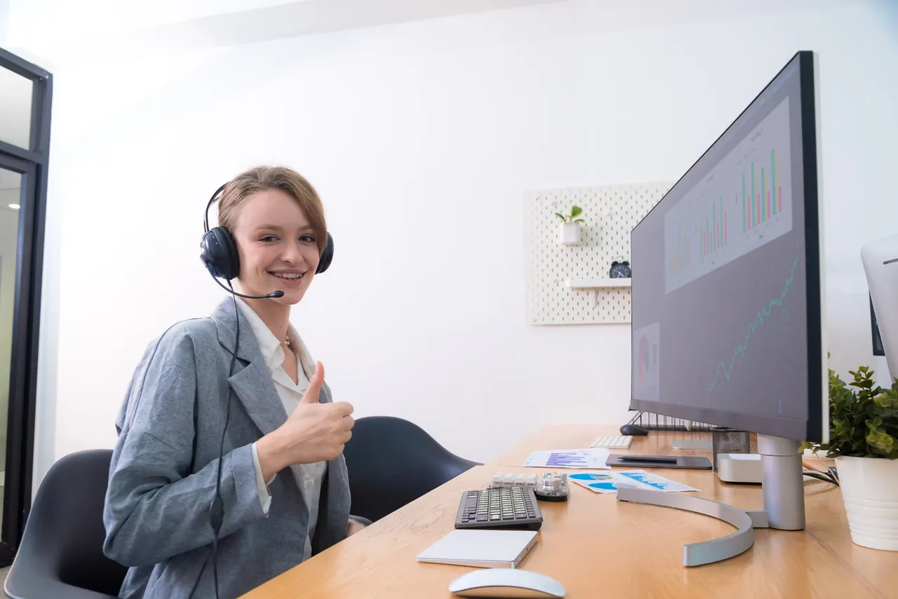 A person wearing a headset at a desk