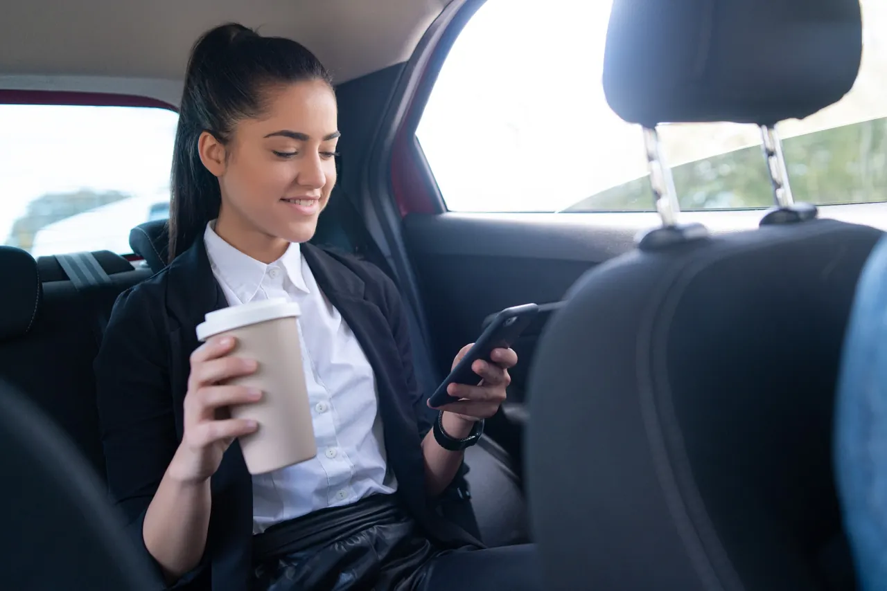 Business passenger using a phone in a car