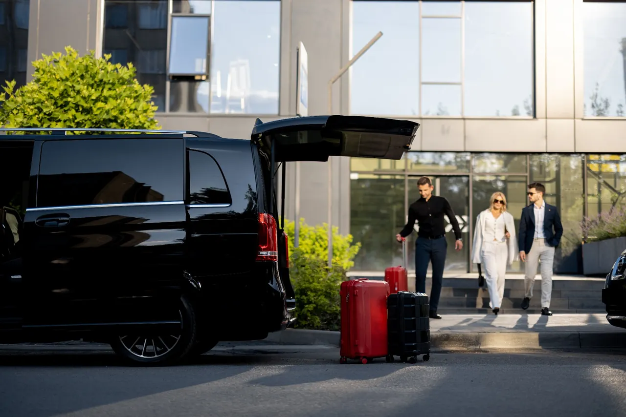 Driver helping passengers with their luggage